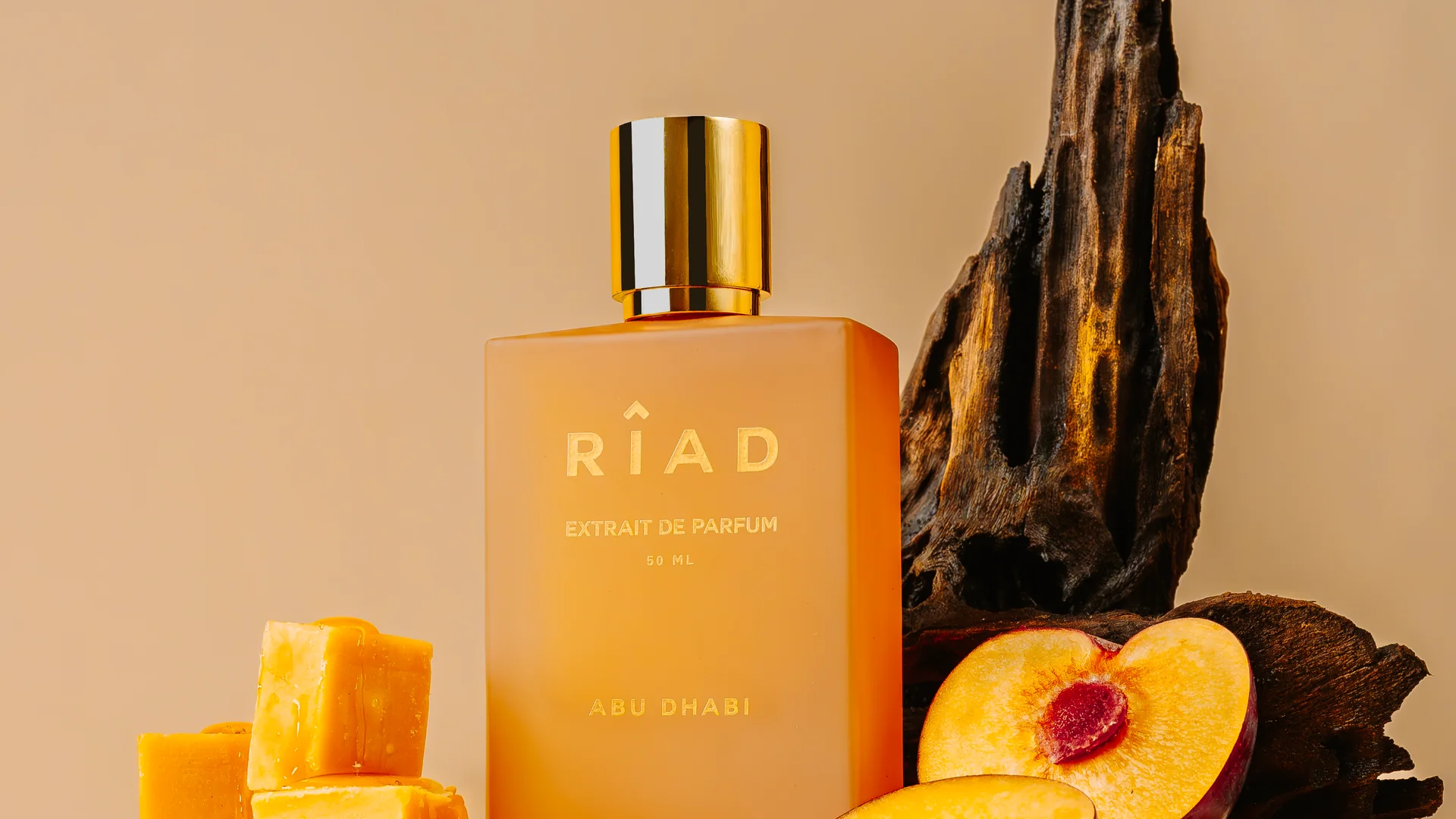Riads flaska Abu Dhabi på ett fat med persika, mango och oudträ